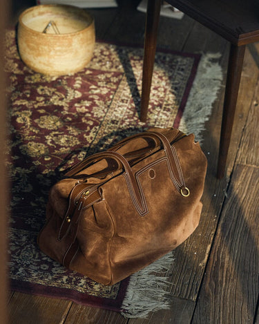 Medium Yore Duffle Bag in Sandal Suede with tan leather trim and white stitching, a stylish travel companion.