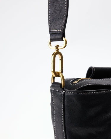 Black leather duffle bag with gold clasp detail and embossed 'songmont' logo on shoulder strap
