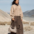 Medium Yore Hobo Bag, cobble grain leather, light grey. Styled with tan jacket and brown skirt in a desert landscape.