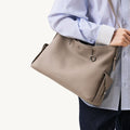 Medium Yore Hobo Bag in Cobble Grain textured leather, worn by a person in a striped shirt.