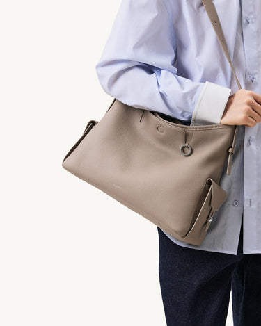 Medium Yore Hobo Bag in Cobble Grain textured leather, worn by a person in a striped shirt.