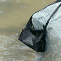Medium Yore Hobo Bag in Onyx: Vegetable-tanned leather hobo bag with white stitching and adjustable strap.