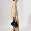 Medium Yore Hobo Bag in Onyx, made from vegetable-tanned leather, held by a man in neutral tones.