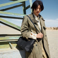 Medium Yore Hobo Bag in Onyx Grain leather with adjustable strap, worn by a model outdoors.