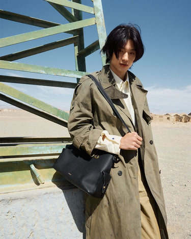 Medium Yore Hobo Bag in Onyx Grain leather with adjustable strap, worn by a model outdoors.