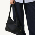 Onyx Grain Medium Yore Hobo Bag in textured leather with gold hardware, worn on shoulder.