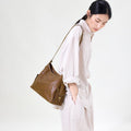 Medium Yore Hobo Bag in Sandal color, made of vegetable-tanned leather with textured finish and multiple exterior pockets.