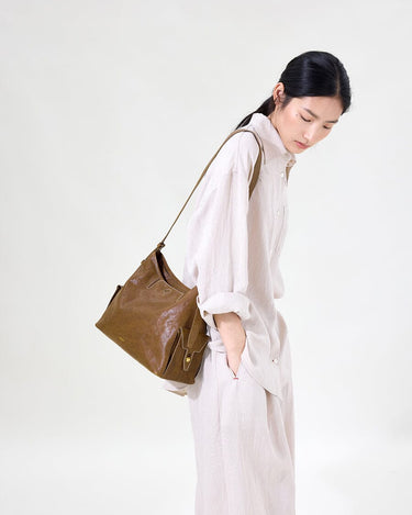 Medium Yore Hobo Bag in Sandal color, made of vegetable-tanned leather with textured finish and multiple exterior pockets.