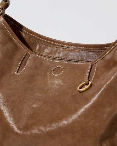 Medium Yore Hobo Bag in Sandal color, vegetable-tanned leather with white stitching and gold hardware.