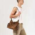 Medium Yore Hobo Bag: Sandal Suede. Brown suede and leather hobo bag with multiple pockets, worn by a model.