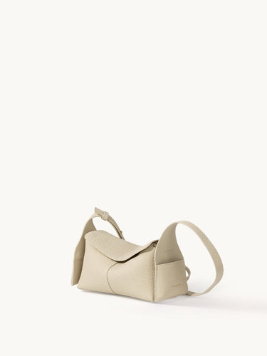 Ivory Mini Drippy Roof Bag in textured leather, showcasing its unique architectural-inspired shape and adjustable strap.