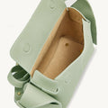Pale green full-grain leather mini bag with adjustable strap and stainless steel hardware.