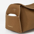Mini Drippy Roof Bag in Mocha, crafted from textured leather with a convenient front pocket holding white earbuds.