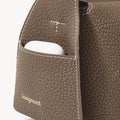 Taupe Mini Drippy Roof Bag: textured leather, front pocket with earbuds, white stitching, gold Songmont logo.