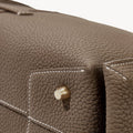 Taupe Mini Drippy Roof Bag crafted from full-grain leather with white stitching and a gold hardware detail.