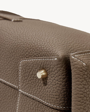 Taupe Mini Drippy Roof Bag crafted from full-grain leather with white stitching and a gold hardware detail.