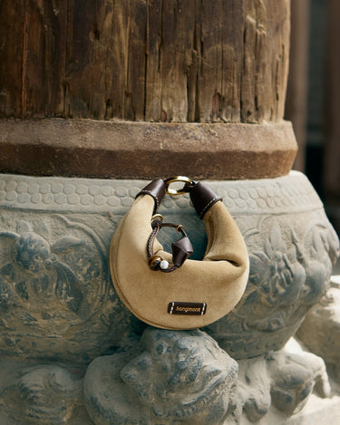 Tan suede Mini Luna AirPods case with dark brown leather accents and gold hardware, featuring 'songmont' logo.