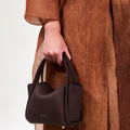 Burgundy Mini Song Bag with pebbled leather texture and gold hardware.