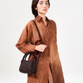 Burgundy Mini Song Bag with gold hardware carried by a woman in a brown ombre dress