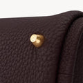 Mini Song Bag in burgundy full-grain leather with gold hardware detail.