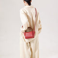Mini Song Bag in lucky red pebbled leather, shown on a person from the back.