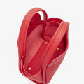 Red pebbled leather Mini Song Bag interior, showing spacious design and golden snap closures.
