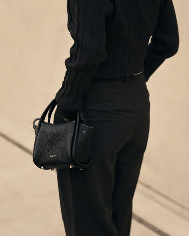 Mini Song Bag in Onyx black full-grain leather with dual top handles and silver hardware.