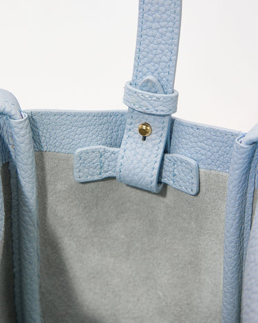 Sky blue leather Mini Song Bag interior detail with adjustable strap and gold hardware.