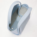 Sky blue pebbled leather Mini Song Bag with grey interior and gold snap closure, open top view.