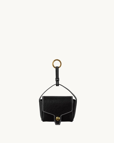 Black vegetable-tanned leather Mini Yore AirPods case with white stitching and gold hardware.