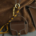 Mini Yore AirPods Case in Sandal color, made of vegetable-tanned leather, attached to a suede bag.