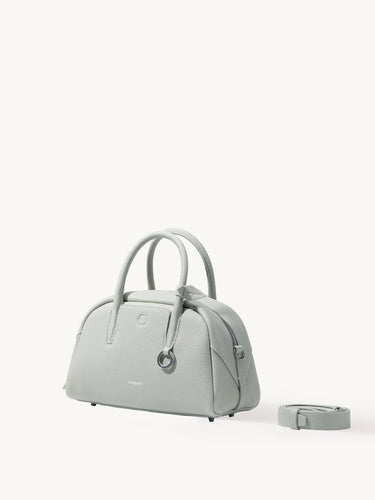 Mini Yore Bowling Bag in Celeste pebble-grain leather with rolled handles and detachable strap.