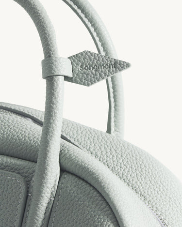 Mini Yore Bowling Bag in Celeste, showing textured leather and embossed Songmont logo detail.