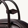 Mini Yore Bowling Bag in ebony full-grain nappa leather with white stitching and debossed Songmont logo.