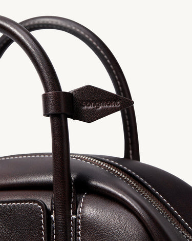 Mini Yore Bowling Bag in ebony full-grain nappa leather with white stitching and debossed Songmont logo.