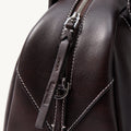 Ebony Mini Yore Bowling Bag: Full-grain leather, white stitching, silver zipper, embossed Songmont logo.