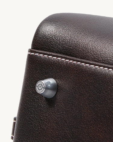 Mini Yore Bowling Bag in dark brown full-grain leather with debossed Songmont logo stud and white stitching.