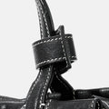 Black leather Mini Yore Duffle Bag detail with white stitching and buckle