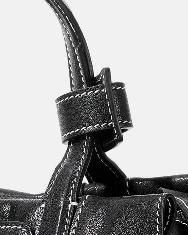 Black leather Mini Yore Duffle Bag detail with white stitching and buckle