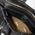 Black Mini Yore Duffle Bag interior with gold zipper, contrast stitching, and zigzag patterned pocket.