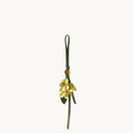 Osmanthus Charm keychain with yellow leather petals and green strap.