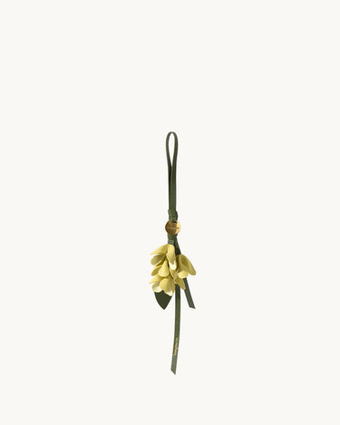 Osmanthus Charm keychain with yellow leather petals and green strap.
