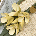 Osmanthus Charm: delicate yellow leather flower accessory with green strap and "Songmont" logo on woven straw background.