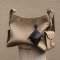 Beige full-grain leather Prism Airpods Case with dark geometric charm. Textured exterior, subtle stitching.