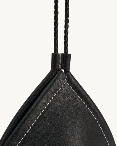 Prism Airpods Case in onyx black leather with white stitching and braided strap.