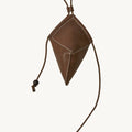 Brown leather Prism Airpods case with white stitching and braided strap with sandalwood beads.