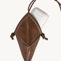 Prism Airpods Case in sandal brown leather with white stitching and wooden beads.