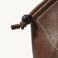 Prism Airpods Case, Sandal color: textured leather, white stitching, dark wood bead detail.