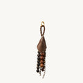 Songmont Prism Seed Charm accessory with brown leather, diverse beads, and gold hardware