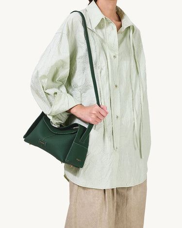 Small dark green full-grain leather drippy roof bag with textured finish and gold hardware.